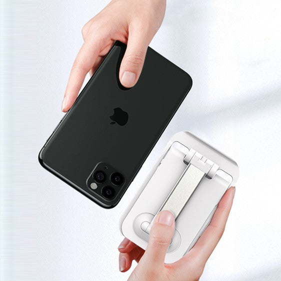 Hands mounting a smartphone on a desktop stand with spring clamp